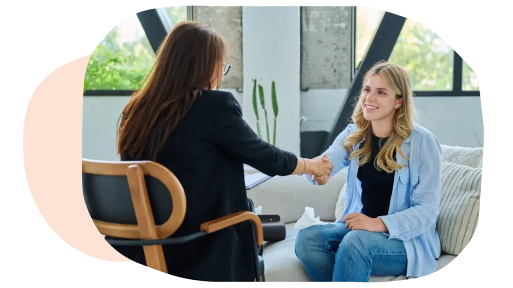 A woman meeting her therapist and shaking hands