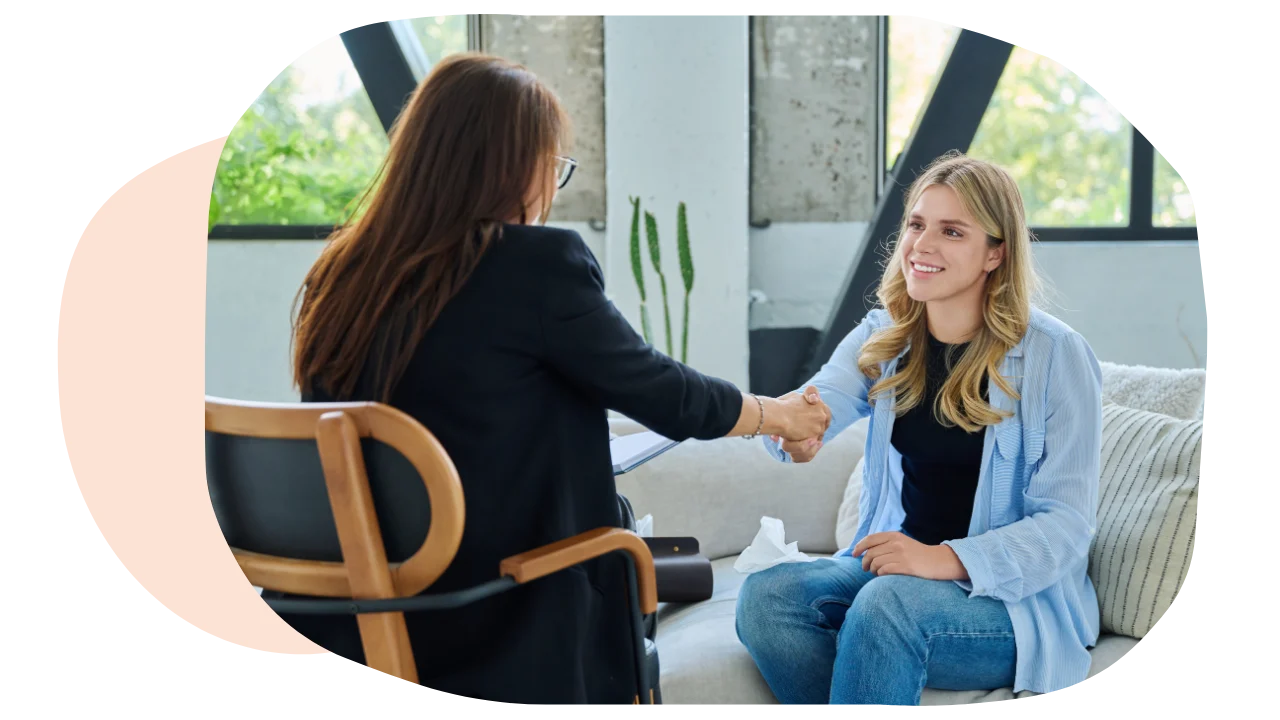 A woman meeting her therapist and shaking hands